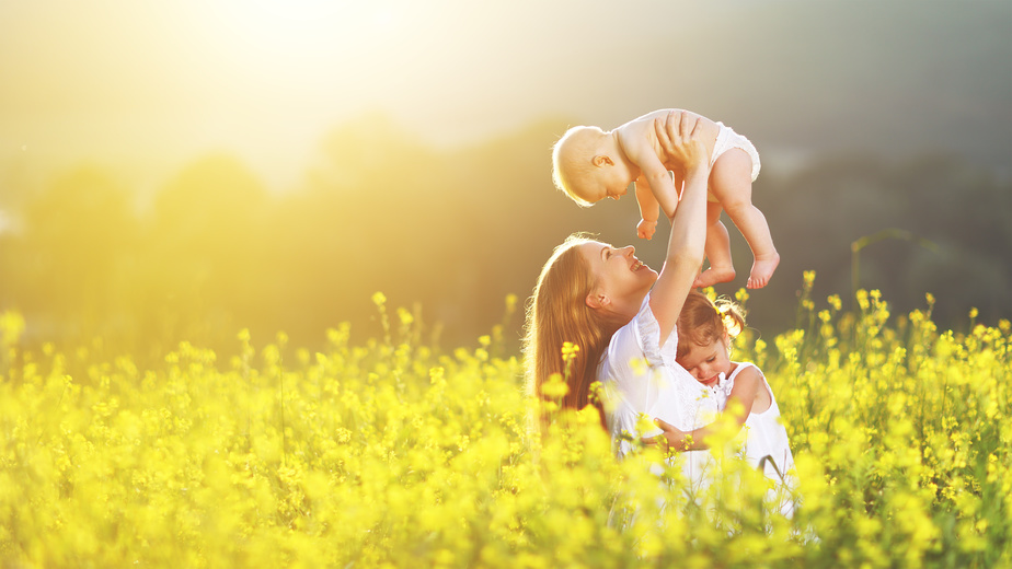 happy family, mother and children daughter and baby son on meadow with yellow flowers | Foto: JenkoAtaman/ Fotolia