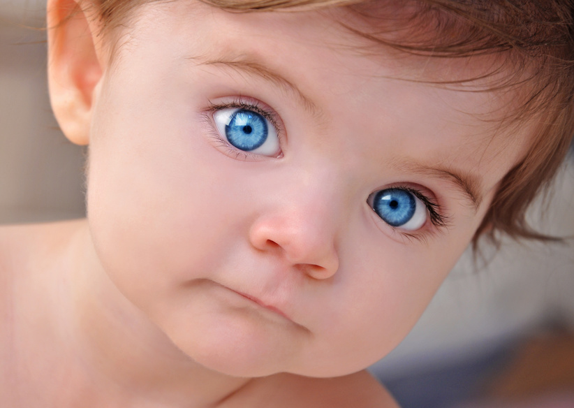 A young little baby is looking at the camera with bright blue eyes. Use it for a child or parenthood concept. | Foto: master1305/ Fotolia